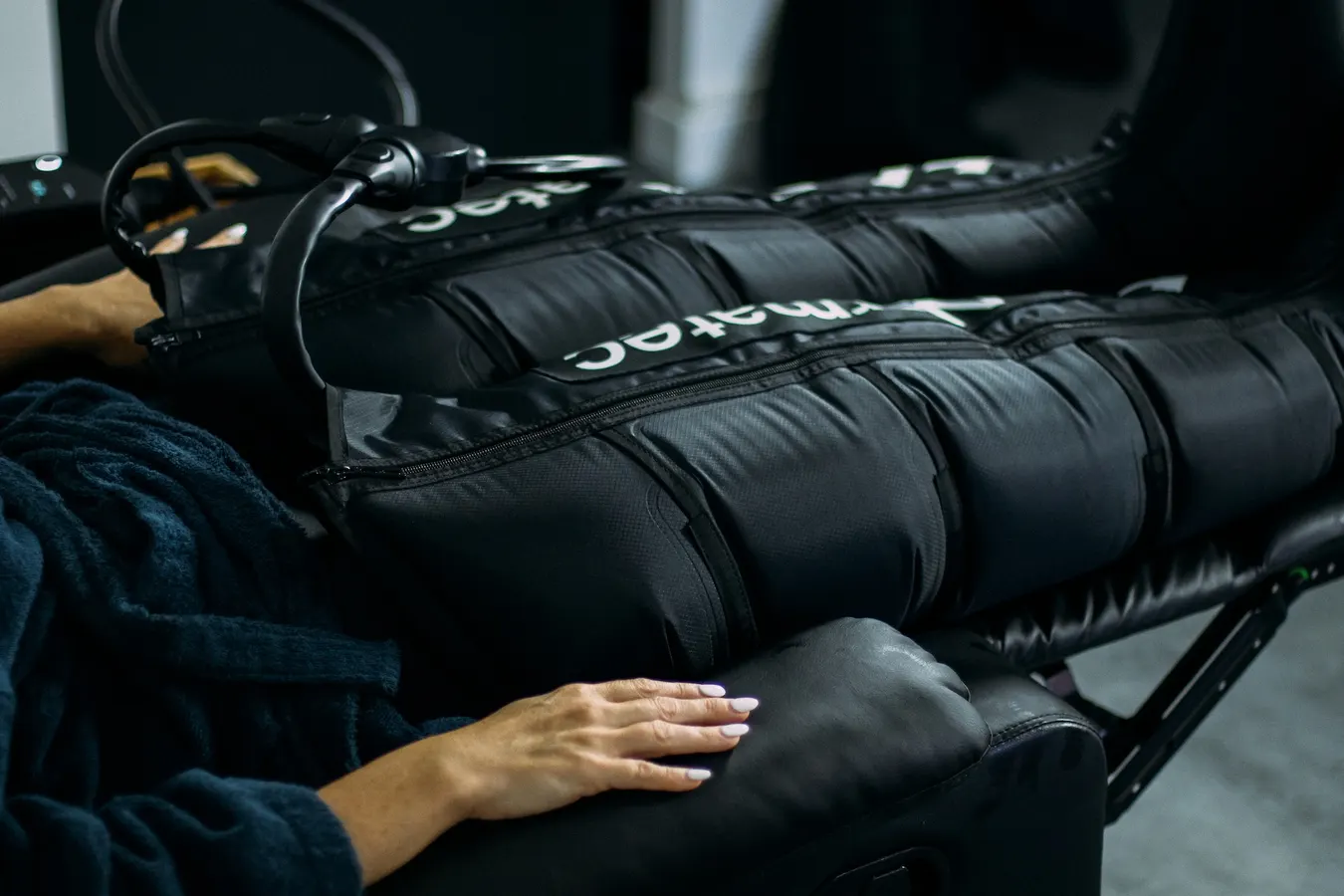 Cliente allongée, jambes dans les bottes de pressothérapie