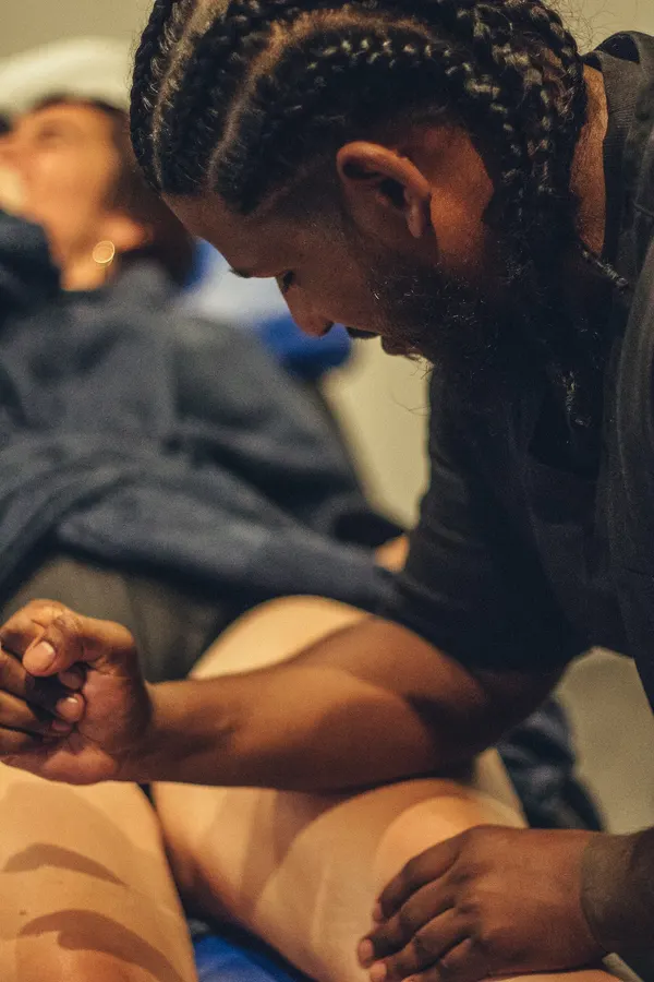 Le praticien masse la jambe d’une cliente allongée