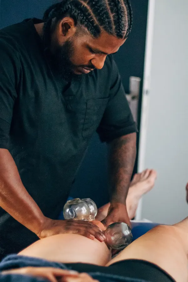 Le praticien pose des ventouses à l’arrière des jambes