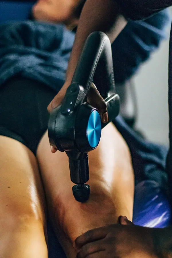 Pistolet de massage sur le haut de la cuisse