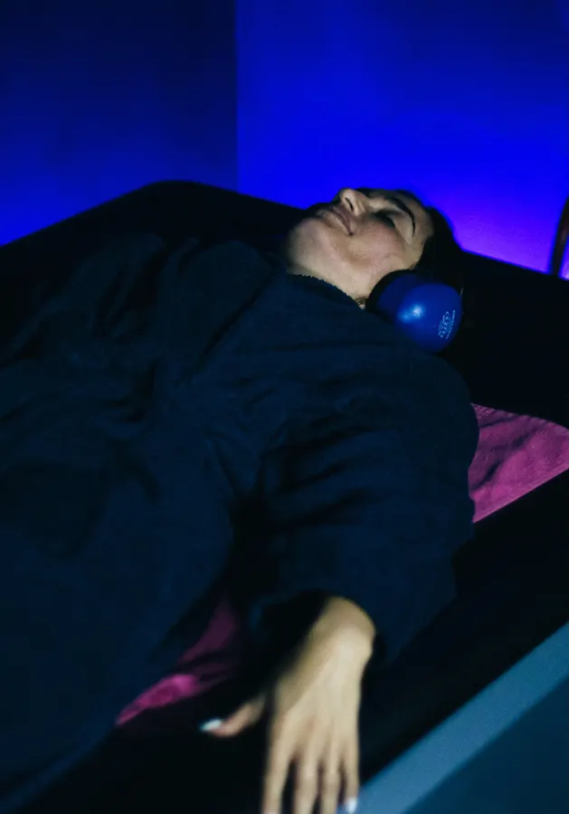 Cliente détendue, allongée sous une lumière bleue